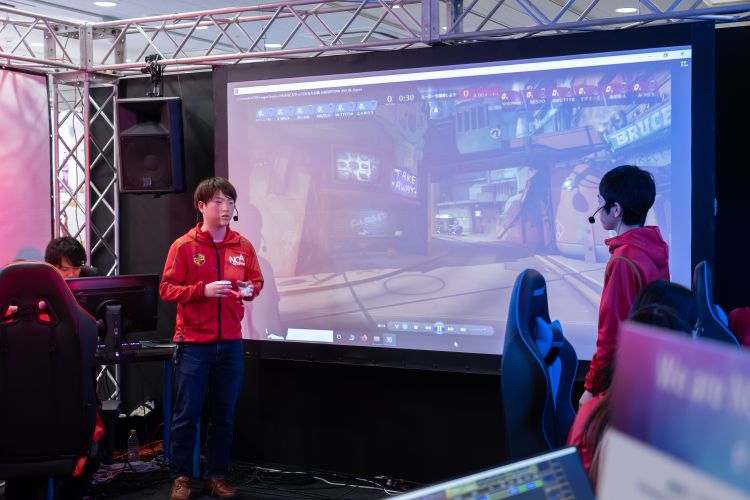 eスポーツブースで打ち合わせをする学生たち