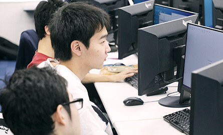 パソコンに向かってプログラミングする学生