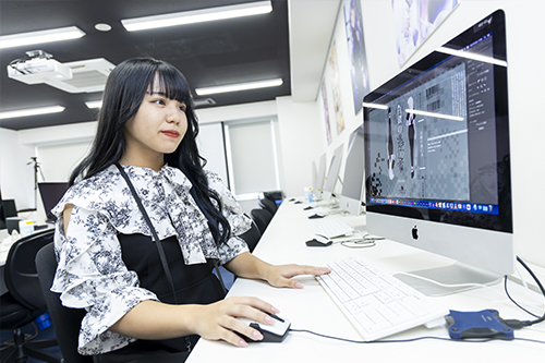 Macを使用しデザインの課題を行う学生